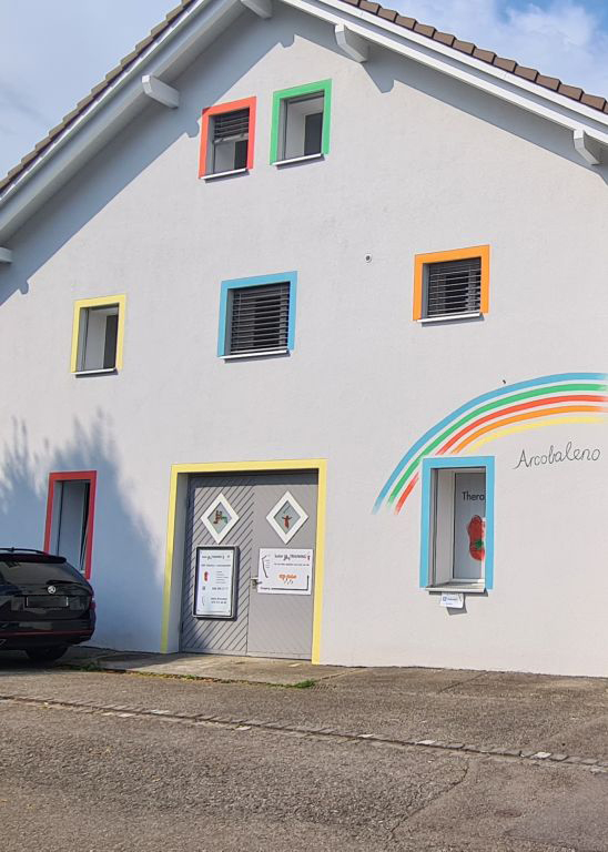 Haus, in welchem sich das Studio für Fussreflexzonenmassage in Wohlen im Kanton Aargau befindet. Das Haus hat bunt umrandete Fenster und ein farbiger Regenbogen ist auf die Hauswand gezeichnet